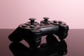 Wireless modern joystick gamepad on pink background, video game concept