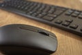 Wireless mouse and keyboard set on top of a wooden office desk, on a workstation Royalty Free Stock Photo
