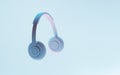 Wireless original headphones with stereo sound in neon light, modern dj earphones on blue background for party