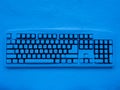 Wireless computer keyboard covered with snow illuminated by blue neon light with title merry christmas Royalty Free Stock Photo