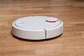 wireless robotic vacuum cleaner on laminate floor close up view. modern smart cleaning technology housekeeping Royalty Free Stock Photo