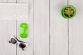 Wireless slim white keyboard and green mouse, glasses, flower on