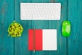 Wireless slim white keyboard and green mouse, notepad, flower on