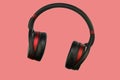 Wireless stereo headset. Black and red cordless headphones. Earphones isolated on pink background with clipping path