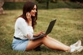 Wireless technologies. Young woman have weekend and sits in the park at daytime