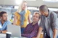 Wireless technology keeps business simple. a diverse group of designers working on a laptop in an office.