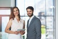 Wireless technology is a key component of modern business. Portrait of a young businessman and businesswoman using a Royalty Free Stock Photo