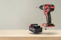 Wireless tools. Cordless drill with drill bit. The screwdriver with the battery removed falls, casting a shadow