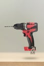 Wireless tools. Cordless drill with drill bit. The screwdriver with the battery removed falls, casting a shadow