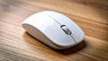 Wireless white computer mouse on a wooden desk surface closeup Royalty Free Stock Photo