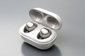 Wireless White Earbuds In A Compact Charging Case On A Clean Gray Background