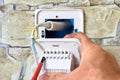 Wiring new electrical socket of thermostat in stone wall, Electrician Installing, connecting live neutral and ground Royalty Free Stock Photo