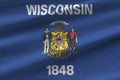 Wisconsin US state flag with big folds waving close up under the studio light indoors. The official symbols and colors