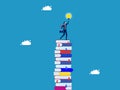 Wisdom for creative thinkers. Businessman on a high stack of books with a light bulb