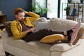 Wise programmer deep in thought, contemplating how to write code for program. Freelancer comfortably laying on sofa Royalty Free Stock Photo