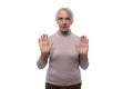 Wise senior woman with gray hair shows disagreement