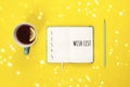 Wish list. Mint Tea cup and modern notebook with to do list on bright yellow desk from above Royalty Free Stock Photo