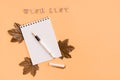 Wish list. Notepad, fountain pen and maple leaves on a yellow background. Top view. Copy space Royalty Free Stock Photo