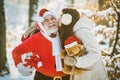 Wish you merry Christmas. Santa with winter girl on snow field. Winter funny people. Royalty Free Stock Photo