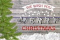 We Wish You A Merry Christmas on wooden board with pine and snow Royalty Free Stock Photo
