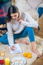 Woman sitting on the floor and prepapring her wishlist