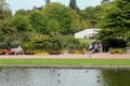 Wisley, Surrey, UK - April 30 2017: Visitors enjoying the beautiful formal landscaped garden with trees and lake Royalty Free Stock Photo