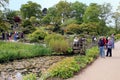 Wisley, Surrey, UK - April 30 2017: Visitors enjoying the beautiful formal landscaped garden with trees and lake Royalty Free Stock Photo