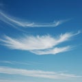 Wispy cirrus clouds, composed of ice crystals, spread across a clear blue sky. These Royalty Free Stock Photo