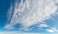 Wispy white clouds drifting across blue sky, panorama format. Royalty Free Stock Photo