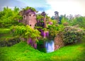 Wisteria flowers in fairy garden of ninfa in Italy - medieval tower ruin surrounded by river