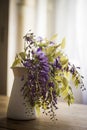 Wisteria inside a jug on a wooden table Royalty Free Stock Photo