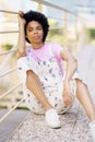 Dreamy black woman sitting near fence Royalty Free Stock Photo