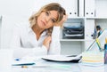 Wistful young woman in white shirt in bright office