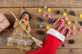The witch Befana and red stocking with sweet coal and candy on rustic wooden background. Italian Epiphany day tradition Royalty Free Stock Photo