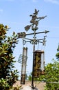 Witch on broom weather vane with bird feeders hanging from it