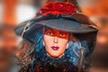 Witch doll with hat and blue hair against blurred background - Halloween decoration - closeup of face