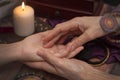 Witch fortune teller reading fortune on girls hand. The concept of magic, predictions of the future, Christmas time.