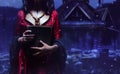 Witch holding a black magic book in night forest Royalty Free Stock Photo