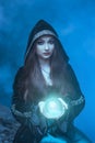 The witch with magic ball in her hands causes a spirits Royalty Free Stock Photo