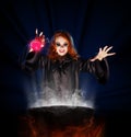 Witch with potion and cauldron on blue rays background Royalty Free Stock Photo