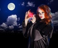 Witch with potion on night sky background Royalty Free Stock Photo