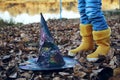 The witch`s hat rests on the dry autumn leaves, halloween, games and entertainment. Lone hat lying on the ground