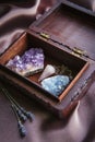 Witch tools inside beautiful old wood box. Rose quartz pendulum  natural amethyst and celestite crystal clusters. Dry lavender flo Royalty Free Stock Photo