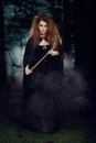 Witch walking through a forest with fog Royalty Free Stock Photo