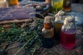 A witchery stuff: multiple tincture bottles, bunches of dry healthy herbs, stack of ancient ritual books, amulets, candles... Royalty Free Stock Photo