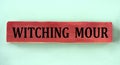 WITCHING HOUR - words on brown wooden block on mint background Royalty Free Stock Photo