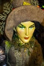 Witchy Halloween Decoration - Detail of beautiful earth witch in brown costume and hat with very green eyes - selective focus