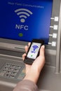 Withdrawing money atm with mobile phone a NFC terminal Royalty Free Stock Photo