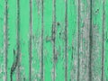 Withered wooden wall with green peeling paint