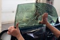 The wizard for installing additional equipment sticks a tint film on the side front glass of the car and flattens it by hand to Royalty Free Stock Photo